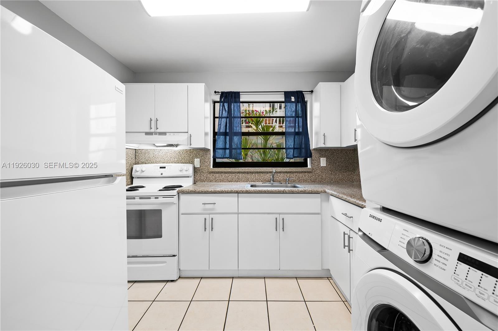 7915 Harding Avenue, Unit 1 Miami Beach, FL 33141 - Photo 10 of 25 a kitchen with a sink a stove and cabinets