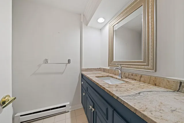 a bathroom with a granite countertop sink and a mirror