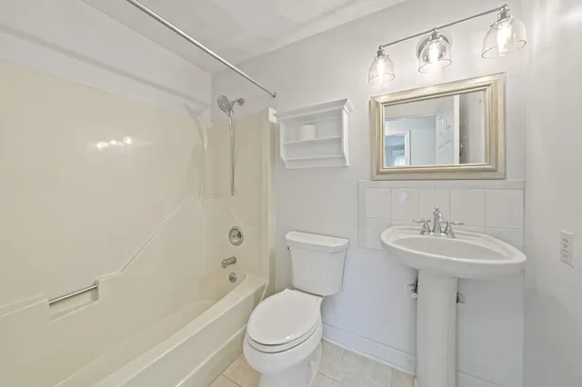 a bathroom with a sink toilet mirror and shower