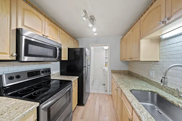 a kitchen with stainless steel appliances granite countertop a stove microwave and sink