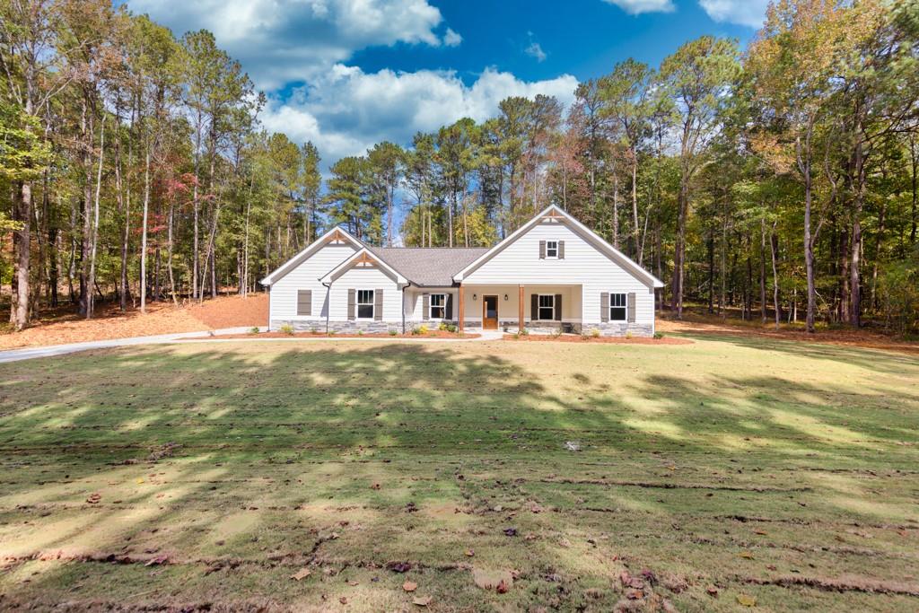 2985 Dewey Hogan Road Monroe, GA 30656 - Photo 1 of 1 a front view of a house with a yard and garage