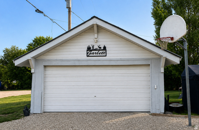 303 North Main Street Grace, ID 83241 - Photo 6 of 22 Detached garage structure with white horizontal siding and a single overhead door