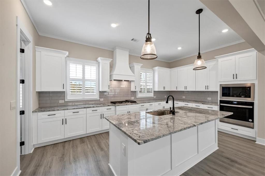 354 Oxford Road Ball Ground, GA 30107 - Photo 14 of 48 a kitchen with stainless steel appliances granite countertop a sink a stove and oven with wooden floor