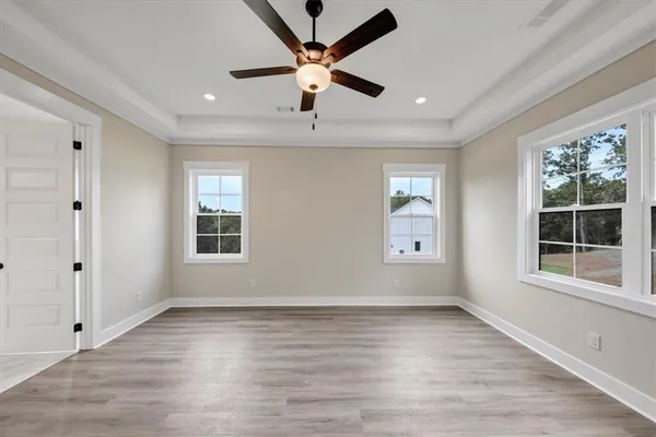a view of an empty room with a window and wooden floor