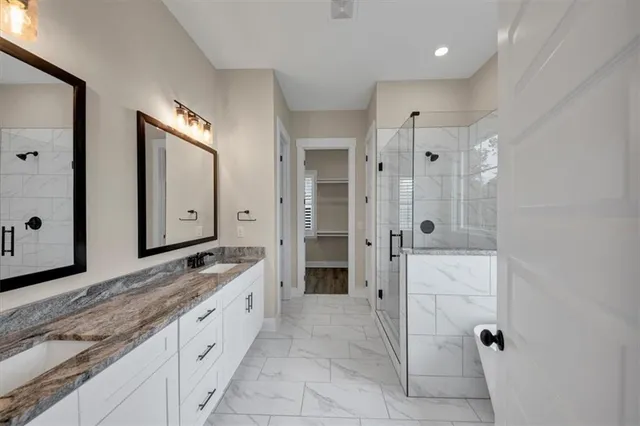 a spacious bathroom with a granite countertop sink mirror and shower