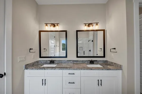 a bathroom with a granite countertop sink and a mirror