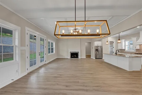 a view of an empty room with kitchen and a window