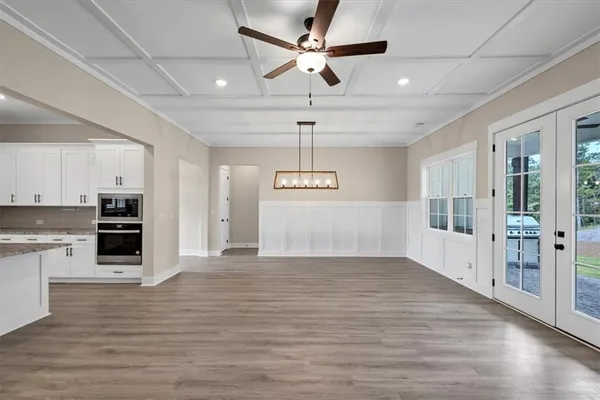 a view of a kitchen with a stove cabinets wooden floor and a ceiling fan