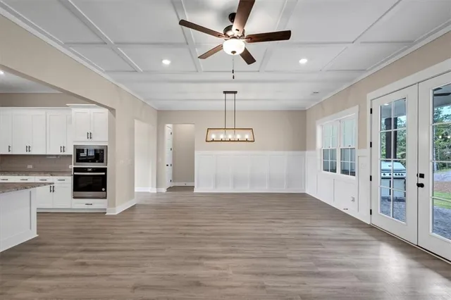a view of a kitchen with a stove cabinets wooden floor and a ceiling fan