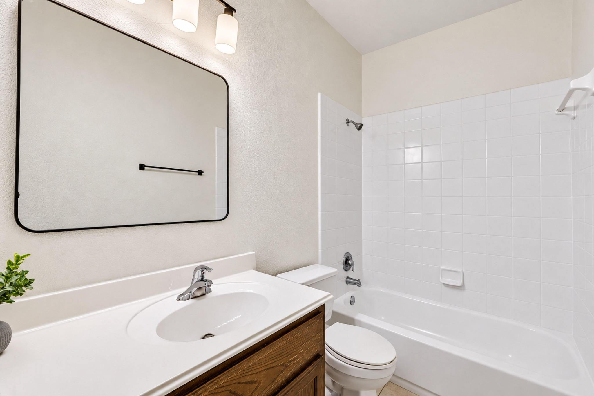 150 Engineers Pass Jarrell, TX 76537 - Photo 20 of 40 Clean tiling and a wood vanity define this functional bathroom space.