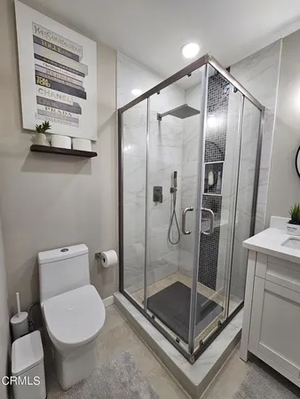 a bathroom with a shower a toilet and a sink
