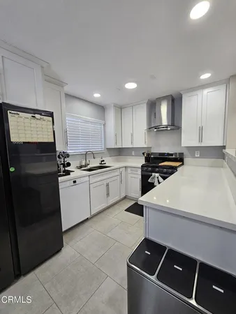 a kitchen with a sink stainless steel appliances and white cabinets