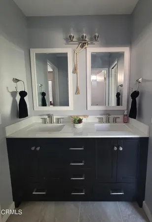 a bathroom with a double vanity sink and a mirror