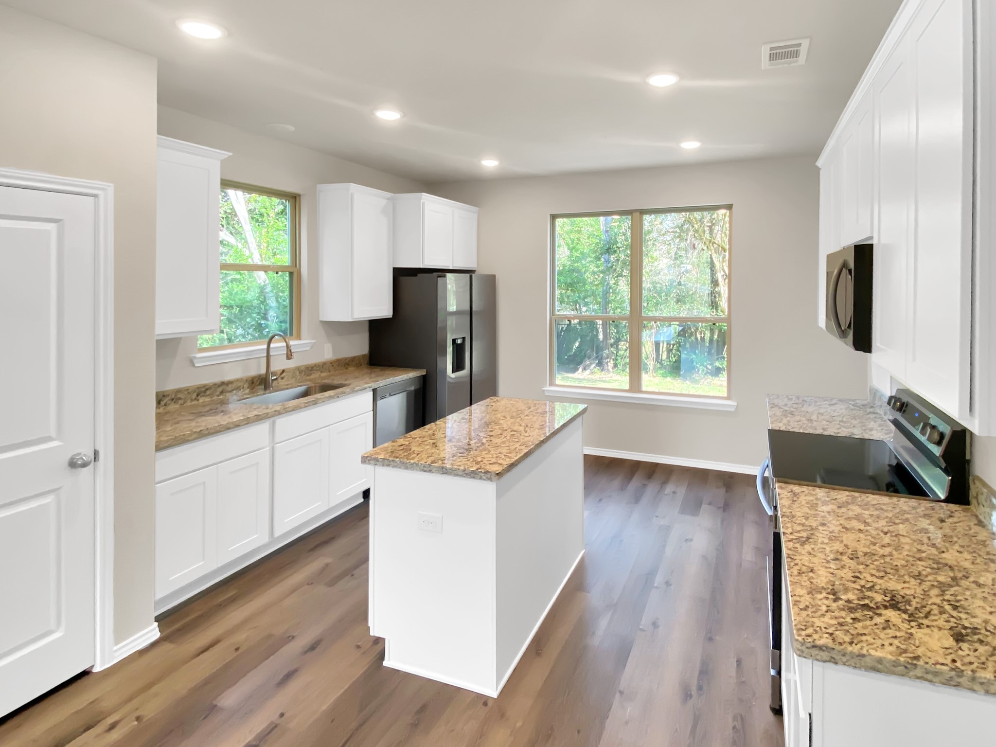 405 Mohawk Drive Conroe, TX 77316 - Photo 7 of 22 a kitchen with a refrigerator a sink dishwasher stove and wooden floor