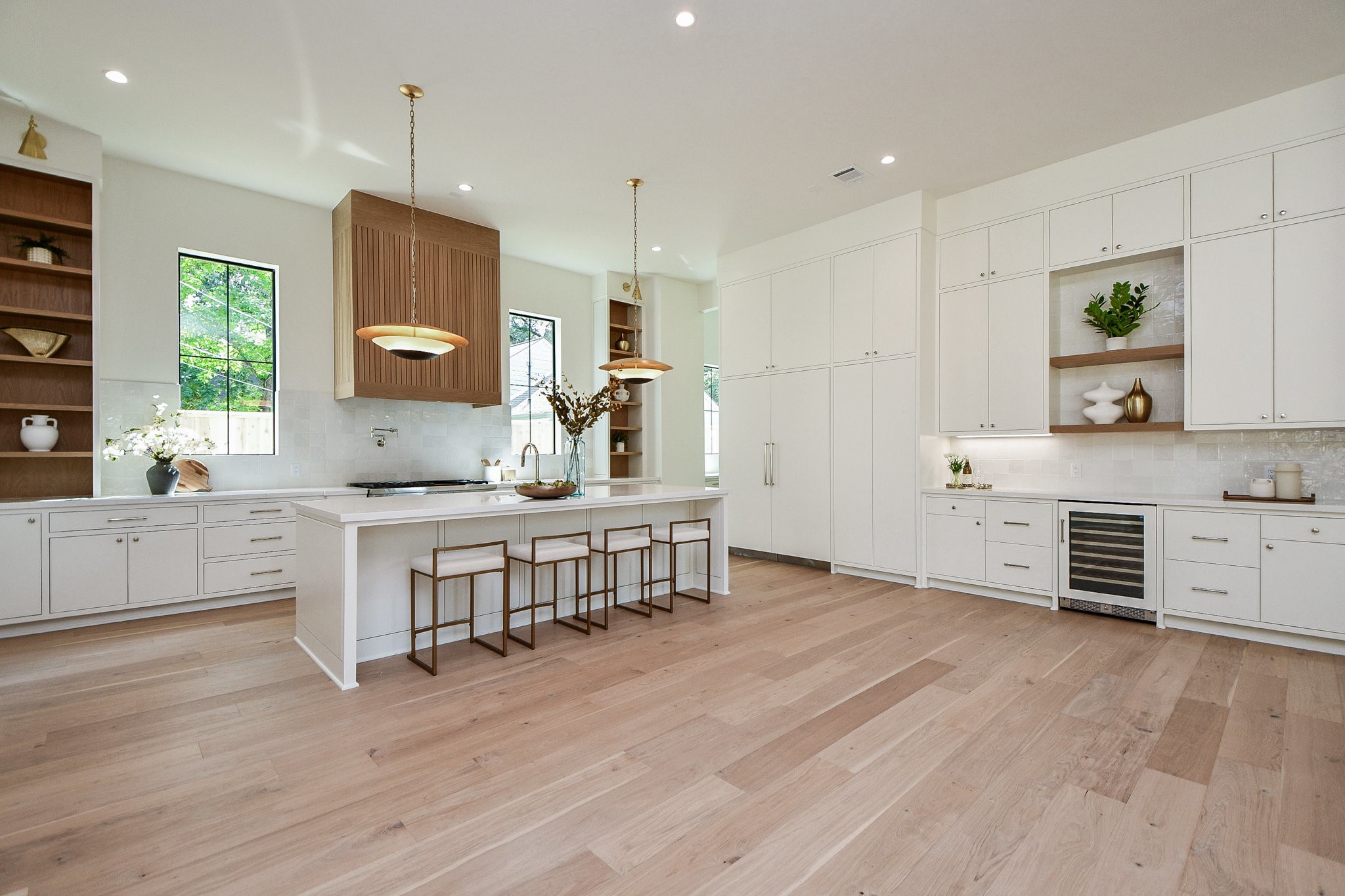 336 West 32nd Street Houston, TX 77018 - Photo 12 of 50 a large white kitchen with stainless steel appliances a large counter top a stove a chimney a sink and a large window