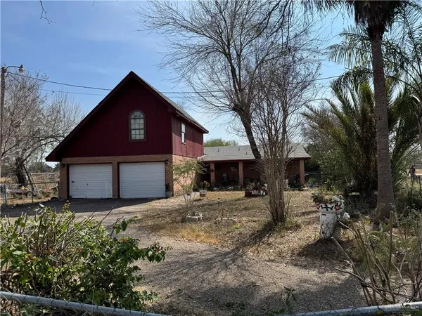 a front view of a house with yard and trees