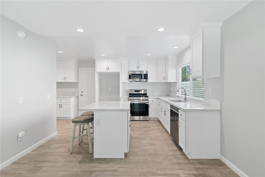 3386 Somis Drive Riverside, CA 92507 - Photo 9 of 31 a kitchen with white cabinets and stainless steel appliances