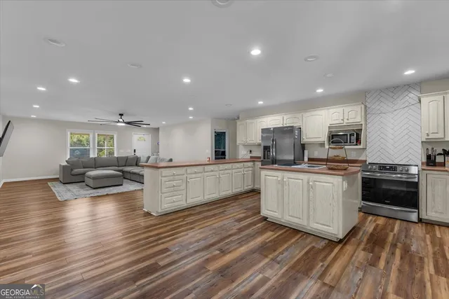 a kitchen that has a sink a stove top oven and refrigerator