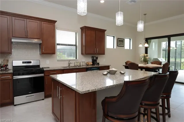 a kitchen with a stove a sink a dining table and chairs