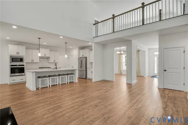 a kitchen with kitchen island a stove a sink a center island and wooden floor