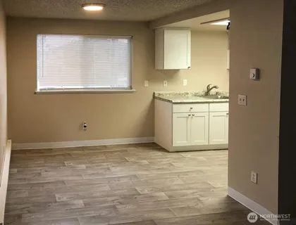 a view of kitchen with granite countertop cabinets and sink