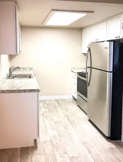 a kitchen with granite countertop a refrigerator and a sink