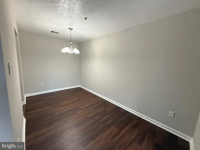 a view of a room with wooden floor and fan