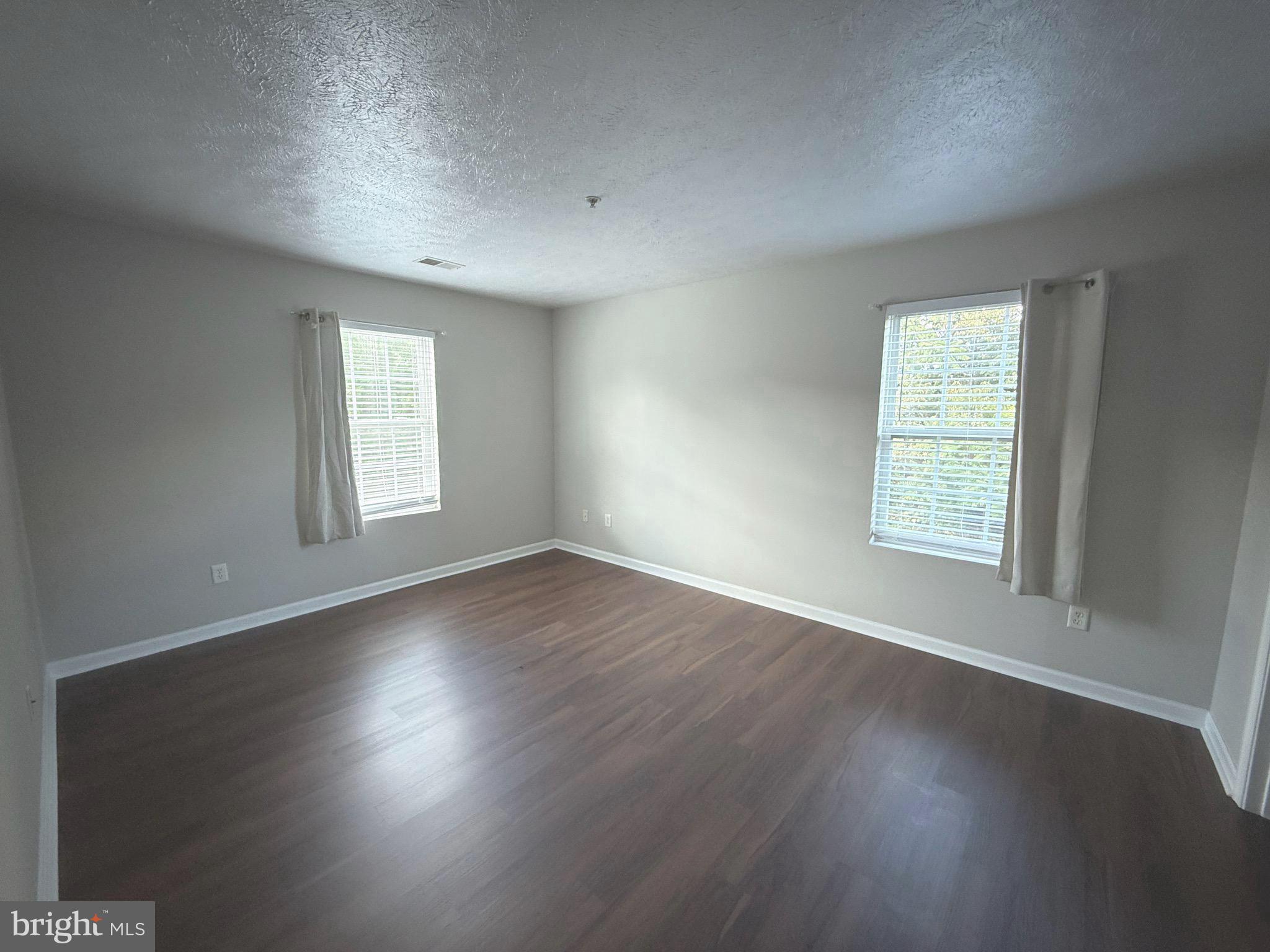 129-8 Brookland Terrace, Unit 8 Winchester, VA 22602 - Photo 5 of 10 an empty room with wooden floor and windows