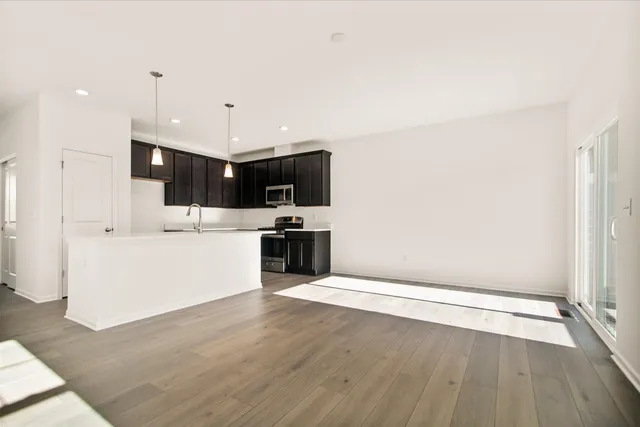a view of kitchen with microwave oven a sink and white cabinets