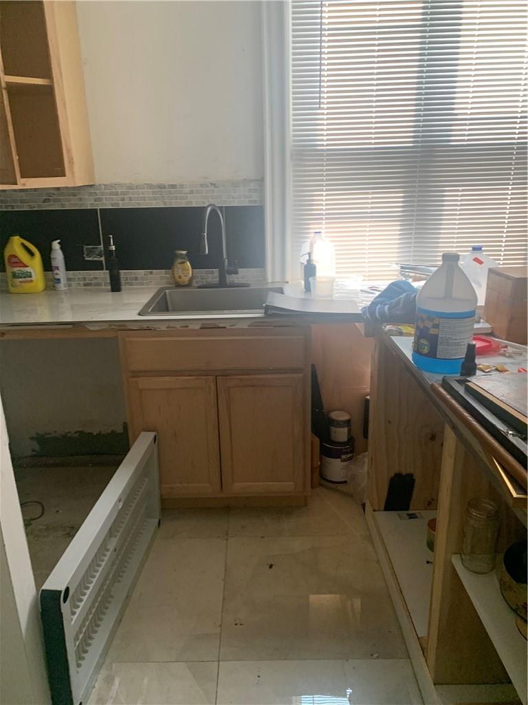 3384 Ely Avenue Bronx, NY 10469 - Photo 2 of 11 a kitchen with a sink and wooden cabinets