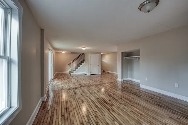 a view of empty room with wooden floor