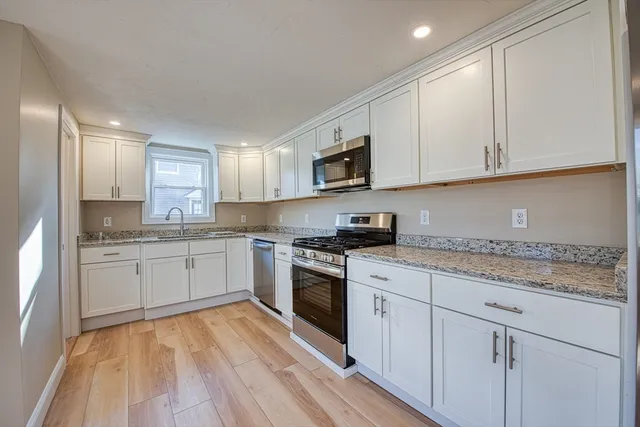 a kitchen with granite countertop white cabinets and white appliances
