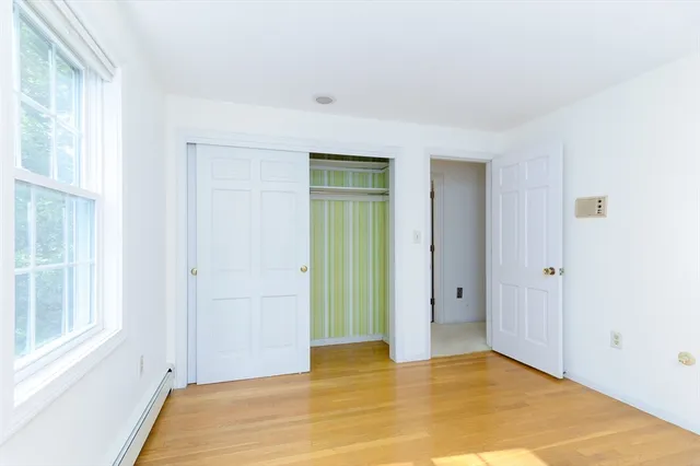 a view of an empty room with window and bathroom