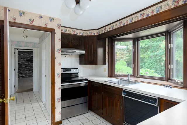 a kitchen with stainless steel appliances kitchen island granite countertop a stove and a sink