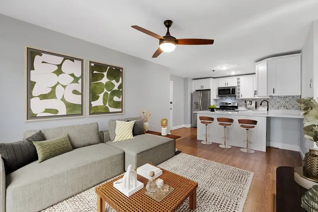 a living room with furniture and kitchen view