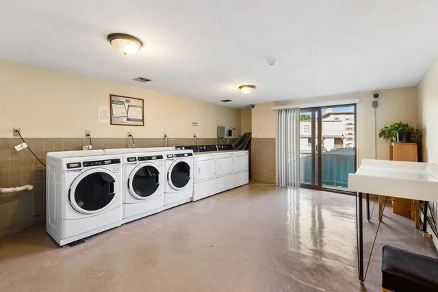 a utility room with stainless steel appliances wooden floors and view living room