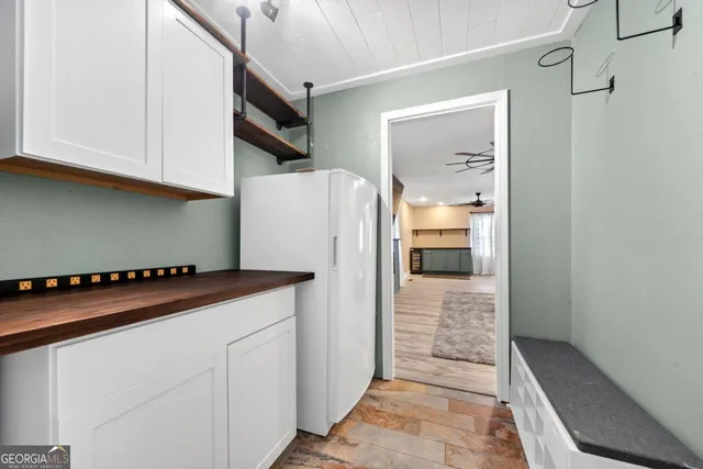 a view of a yard with plants and large trees