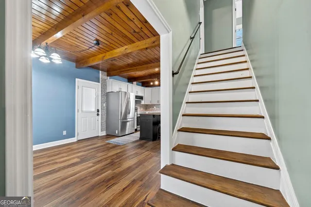 a kitchen with stainless steel appliances granite countertop a table chairs refrigerator and sink