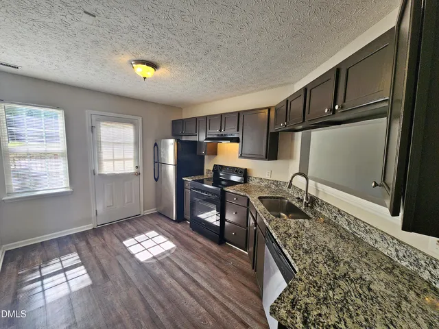 a view of a room with wooden floor chandelier and window