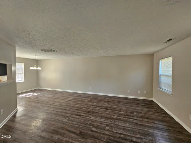 a view of a room with wooden floor door and windows