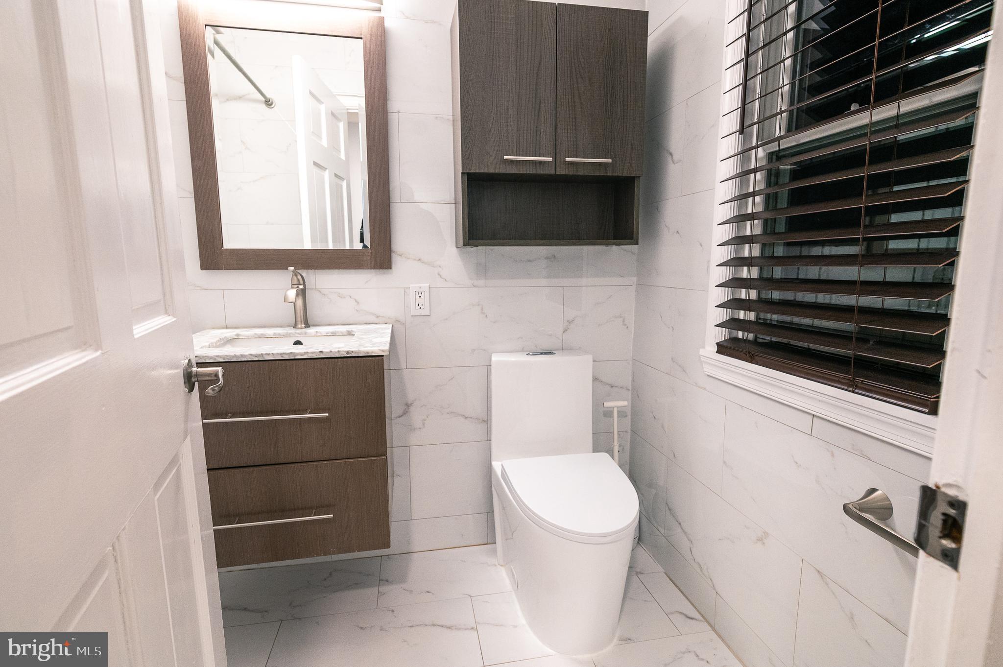 7722 Old York Road Elkins Park, PA 19027 - Photo 28 of 37 a bathroom with a toilet a sink and a mirror