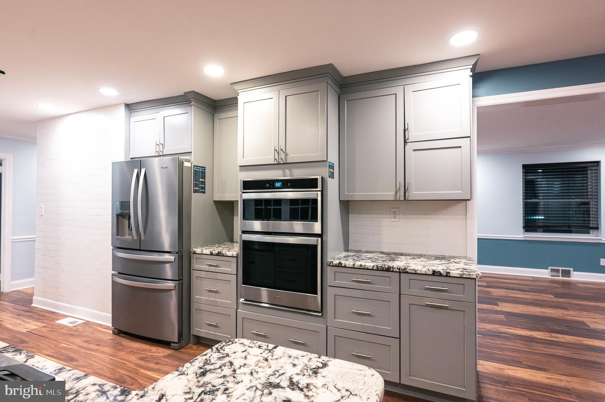 7722 Old York Road Elkins Park, PA 19027 - Photo 8 of 37 a kitchen with stainless steel appliances kitchen island granite countertop a refrigerator stove and oven