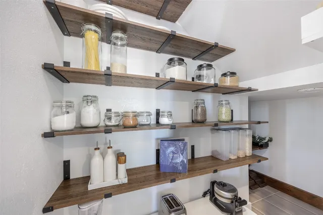 a kitchen with lots of stainless steel appliances a wooden table and chairs