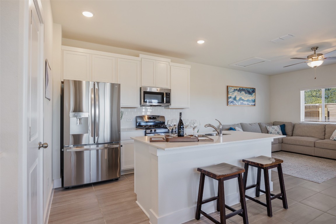 322 Furlong Drive Georgetown, TX 78626 - Photo 23 of 23 a kitchen with stainless steel appliances granite countertop a refrigerator a stove a sink a dining table and chairs