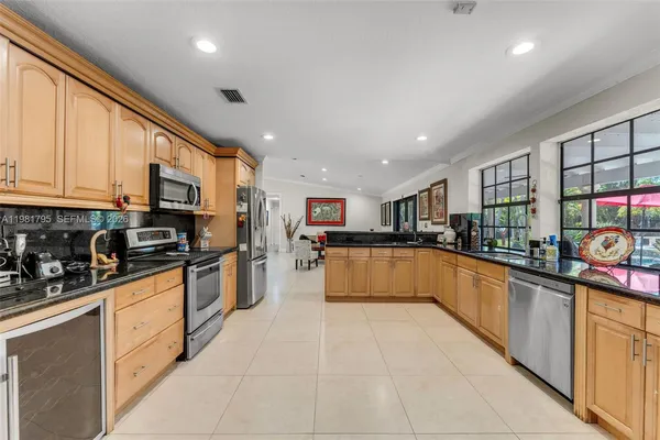a large kitchen with stainless steel appliances granite countertop a large counter top and a stove top oven