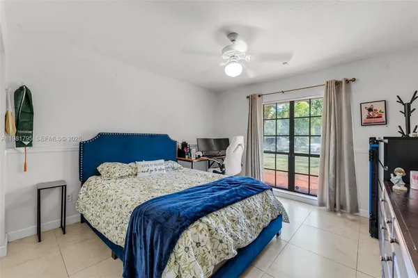 a bedroom with a bed a dresser and flat screen tv