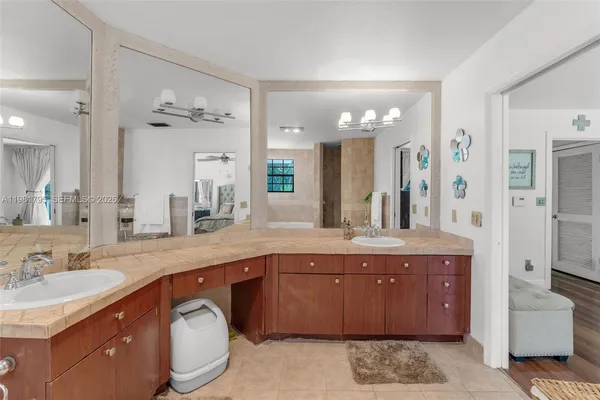 a spacious bathroom with a granite countertop sink a toilet a mirror and shower