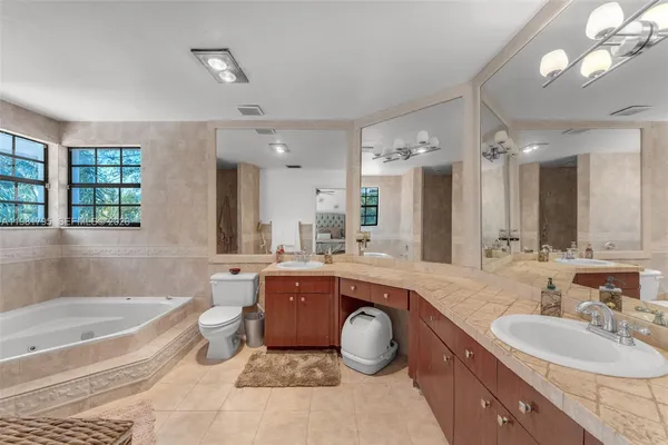 a large spacious bathroom with a bathtub a double vanity sink and a large mirror