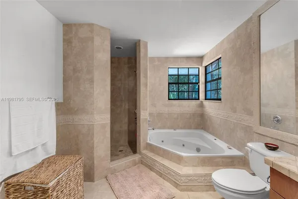 a bathroom with a granite countertop bathtub shower and toilet
