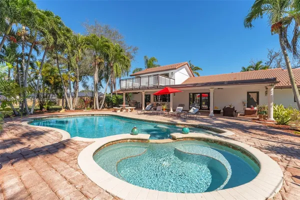 a view of a house with swimming pool and a small yard